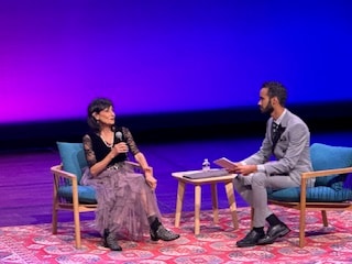 Two people speaking in an onstage interview